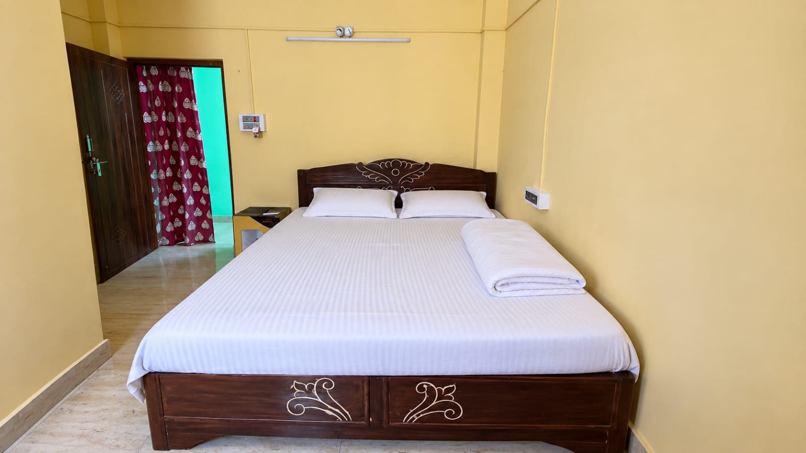 Neat double bed guest room at Anandamoyee Guest House